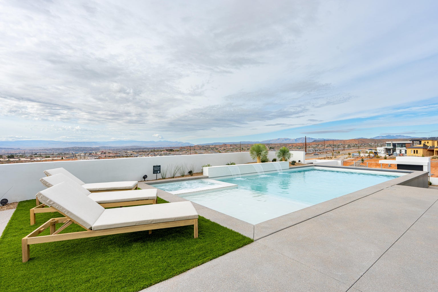 pool in desert with lawn chairs